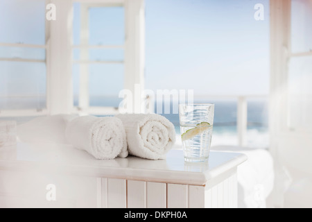 Glas Wasser und Handtücher auf Tisch Stockfoto