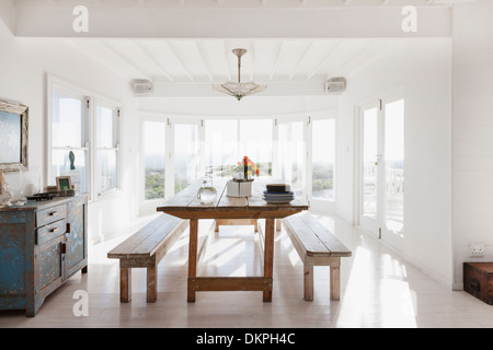 Holztisch mit Bänken im sonnigen Speisesaal Stockfoto