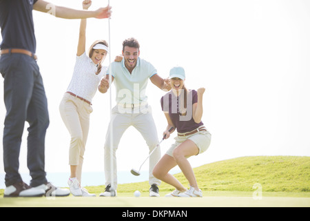 Freunde spielen Golf auf Kurs Stockfoto