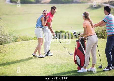 Freunde Lachen auf Golfplatz Stockfoto