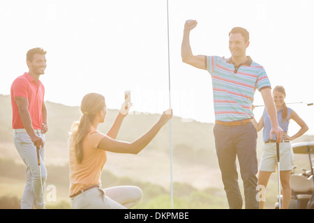 Freunde jubeln auf Golfplatz Stockfoto