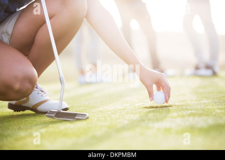 Frau Golfball aus Loch entfernen Stockfoto