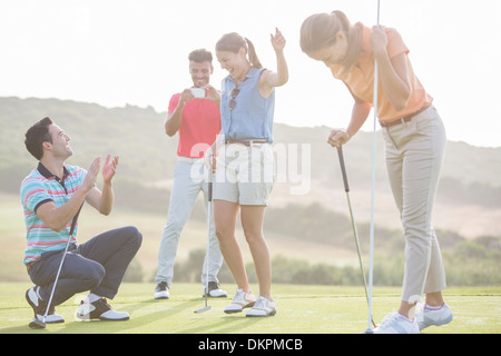 Freunde spielen Golf auf Kurs Stockfoto