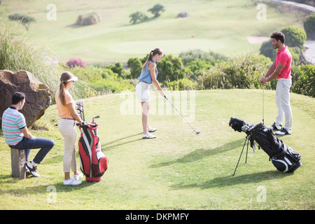 Freunde gerade Frau Abschlag am Golfplatz Stockfoto