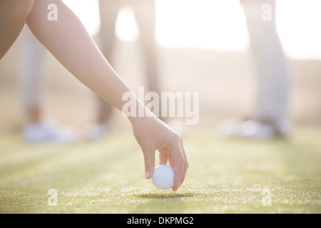 Frau Abschlag Golfball auf Kurs Stockfoto