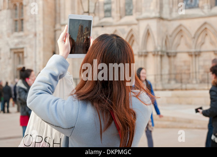 Junge Frau fotografiert Fotos vor dem Minster mit digitalem Tablet York North Yorkshire England Großbritannien Großbritannien Großbritannien Großbritannien Großbritannien Stockfoto