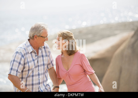 Älteres Paar halten die Hände am Strand Stockfoto