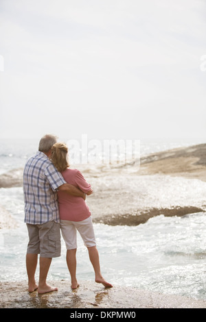 Älteres Ehepaar umarmt am Strand Stockfoto