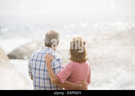 Älteres Ehepaar umarmt am Strand Stockfoto