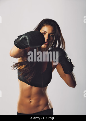 Porträt der jungen Sport Trägerin Boxhandschuhe Boxen training. Gemischte Rassen Weibchen üben, Boxen, Blick in die Kamera. Stockfoto