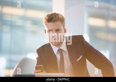 Geschäftsmann mit Handy im Büro Stockfoto