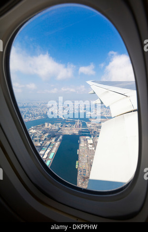 Bucht von Tokio und die Rainbow Bridge gesehen durch ein Flugzeugfenster an einem sonnigen Tag. Stockfoto