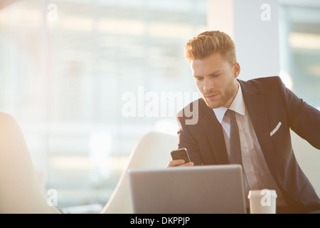 Geschäftsmann mit Handy im Büro Stockfoto