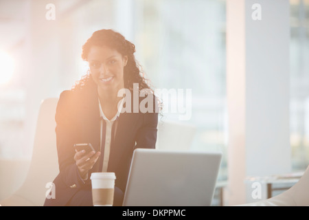 Geschäftsfrau mit Handy im Büro Stockfoto