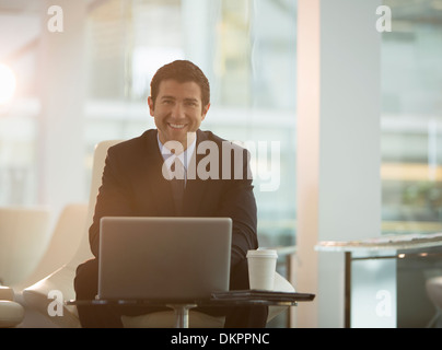 Geschäftsmann mit Laptop im Büro Stockfoto