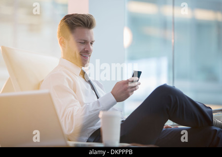 Geschäftsmann mit Handy im Büro Stockfoto