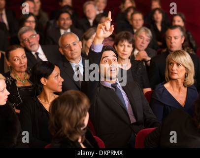 Mann, die Hand im Theater Publikum heben Stockfoto