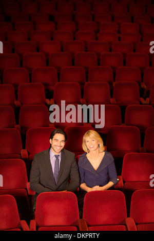 Porträt der lächelnde paar sitzt im leeren theater Stockfoto