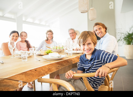 Familie zusammen am Tisch lächelnd Stockfoto