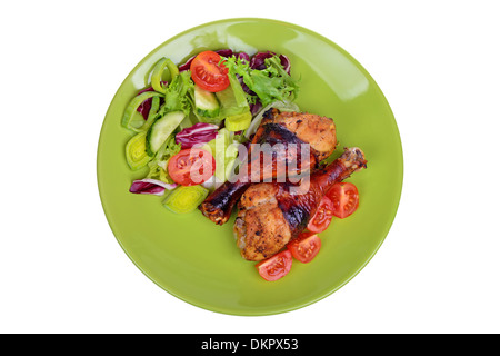 Gegrillte Hühnerbein mit Gemüse auf dem Teller. Isoliert auf einem weißen Stockfoto