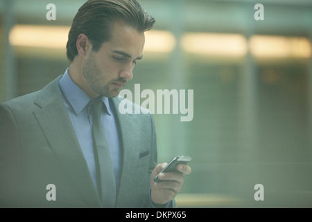 Geschäftsmann mit Handy im Büro Stockfoto