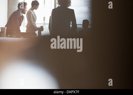 Silhouette der Geschäftsleute sprechen in treffen Stockfoto