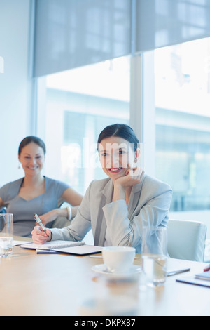 Geschäftsfrau, die lächelnd im Konferenzraum Stockfoto