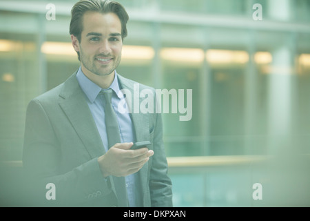 Geschäftsmann mit Handy im Büro Stockfoto