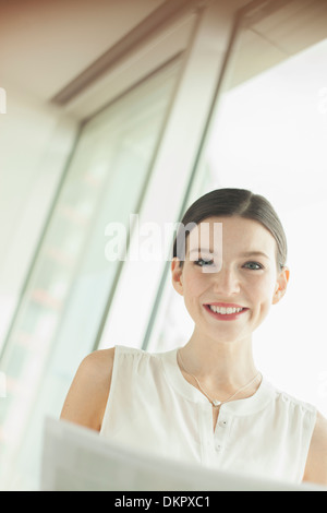 Geschäftsfrau, die lächelnd im Büro Stockfoto