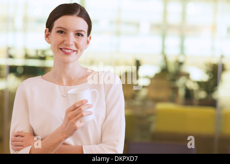 Geschäftsfrau, die lächelnd im Büro Stockfoto