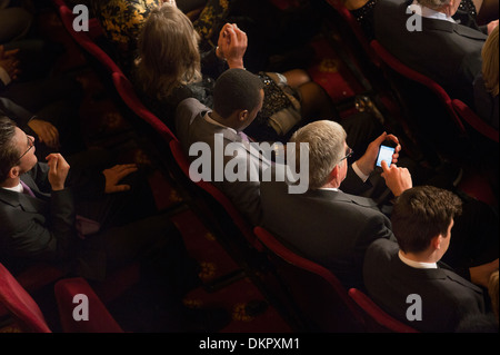 Mann mit Handy im Theater-Publikum Stockfoto