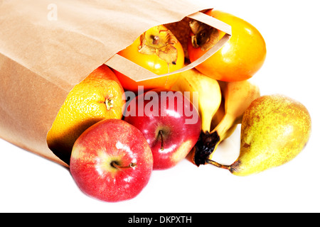 Äpfel, Kaki und Birnen auf dem Boden liegend in Papiertüte. Isoliert auf weiss. Stockfoto