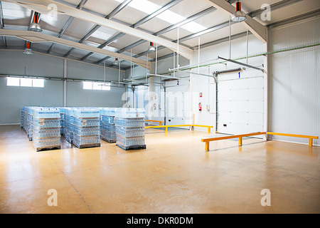 Paletten mit Wasserflaschen in leere Lager Stockfoto