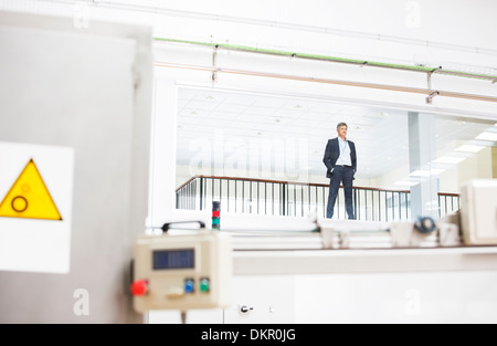 Geschäftsmann, schauen Beobachtungsfenster in Fabrik Stockfoto