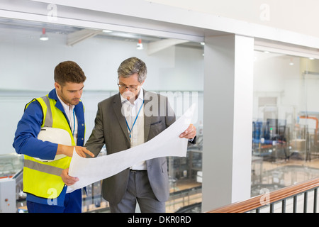 Supervisor und Arbeiter lesen Blaupausen in Fabrik Stockfoto