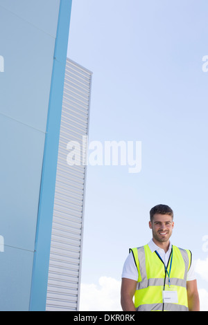 Arbeiter, die lächelnd unter Hochhäuser Stockfoto