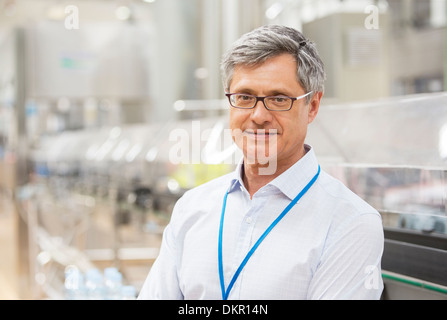 Geschäftsmann lächelnd in Fabrik Stockfoto