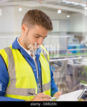 Arbeiter mit Zwischenablage in Fabrik Stockfoto