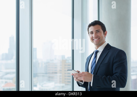 Geschäftsmann mit Handy im Büro Stockfoto