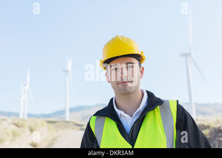 Arbeitnehmer, die durch Windkraftanlagen in ländlichen Landschaft stehen Stockfoto