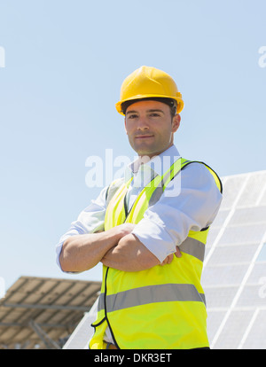 Arbeiter von Sonnenkollektoren in ländlichen Landschaft stehend Stockfoto