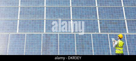 Arbeiter, die Prüfung von Solar-Panel in ländlichen Landschaft Stockfoto