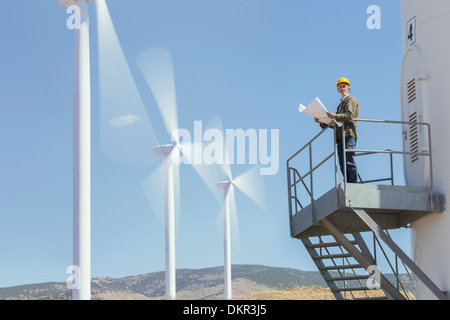 Arbeiter auf Windkraftanlage in ländlichen Landschaft stehend Stockfoto