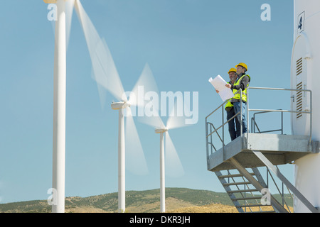 Arbeitnehmer auf Windkraftanlage in ländlichen Landschaft stehend Stockfoto