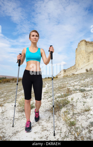 Junge Frau mit trekking-Stöcke in Bergen. Stockfoto