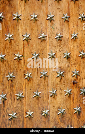 Nahaufnahme einer mittelalterlichen Holztür mit sternförmigen Nieten. Stockfoto