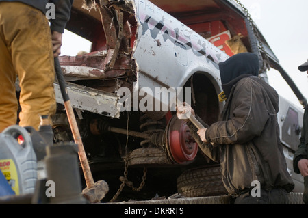 Banger Rennmechaniker Reparatur der Karosserie auf Stock Car-Autos mit einem Vorschlaghammer Rennen Rennen Grube Gruben Reparatur Hit schlagen mit Stockfoto