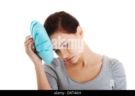 Junge schöne Frau ist Haveng Kopfschmerzen und Holding Eisbeutel. Isoliert auf weiss. Stockfoto