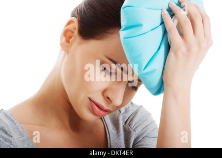 Junge schöne Frau ist Haveng Kopfschmerzen und Holding Eisbeutel. Isoliert auf weiss. Stockfoto