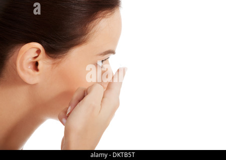 Junge schöne Frau Kontaktlinsen setzen. Isoliert auf weiss. Stockfoto